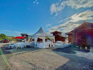 a white tent with tables and chairs in a parking lot at HOMESTAY KAYU in Kajang