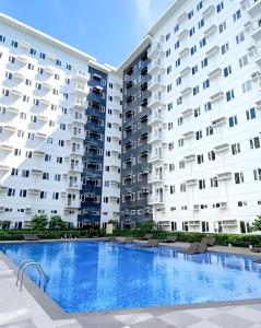 duży budynek apartamentowy z dużym basenem w obiekcie Casa Aria @ SMDC Charm Residences w mieście Manila