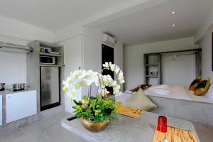 فندق ساموي بيتش ريزيدنس في شاطئ تشاوينغ: غرفة معيشة مع سرير وطاولة مع زهور