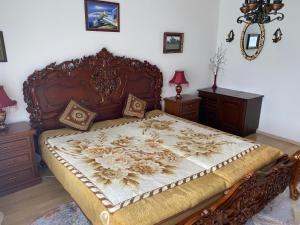 Schlafzimmer mit einem großen Bett mit einem Kopfteil aus Holz in der Unterkunft Pension Hadanig in Techelsberg am Worthersee