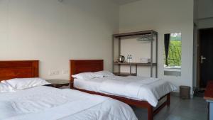1 dormitorio con 2 camas y espejo en Zen Vista en Vālpārai