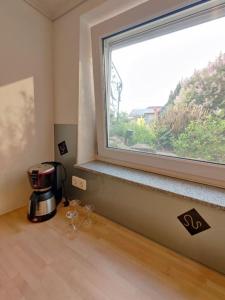 een koffiezetapparaat op een aanrecht naast een raam bij Abschalten und Urlaub machen im Herzen der Rhön in Münnerstadt