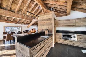 a kitchen with wooden walls and a black counter top at Résidence Fontany - Chalets pour 12 Personnes 044 in Les Allues