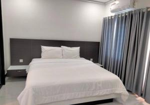 a bedroom with a large bed with white sheets at LSP Hotel & Apartment in Phnom Penh