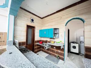 Jazīrat al ‘Awwāmīyah的住宿－River view，厨房配有蓝色橱柜、水槽和微波炉
