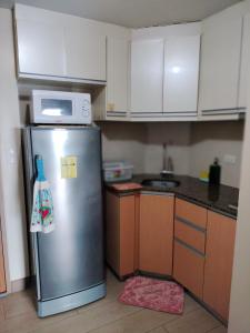 een keuken met een roestvrijstalen koelkast en een magnetron bij Palmtree Villas Two Condotel Near Airport in Manilla