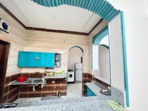 - une cuisine avec des placards bleus et un évier dans l'établissement River view, à Jazīrat al ‘Awwāmīyah