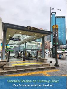 a station on a subway line with a sign at Evermore #Sinchon station 5min #Seogang station 1min in Seoul