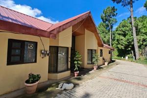 a house with plants and a sidewalk in front of it at 3 Br Harrington Villa Kitchen Living room AC in Kasauli