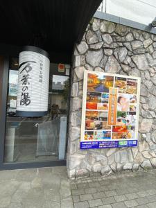 a sign on the side of a stone building at 花沢民宿 in Odawara