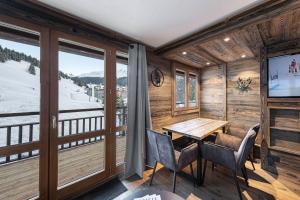 a room with a table and chairs and a large window at Residence - Pièces 134 in Courchevel