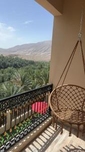 a swing on a balcony with a view of the desert at WADI BANI KALED REST HOUSE in Dawwah