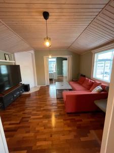 a living room with a red couch and a flat screen tv at Idyllinen puutaloasunto in Vaasa