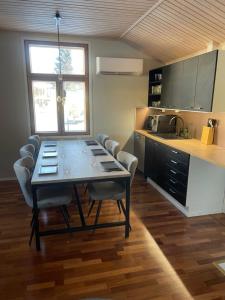 a dining room table with chairs and a kitchen at Idyllinen puutaloasunto in Vaasa
