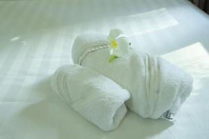 un asciugamano bianco con un fiore sopra di NỤ CƯỜI MŨI NÉ HOTEL a Ấp Thiện Long