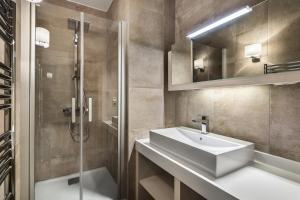 a bathroom with a sink and a shower and a mirror at Résidence Carre Blanc - 3 Pièces pour 4 Personnes 504 in Courchevel