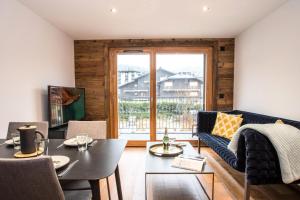 een woonkamer met een bank en een tafel bij Résidence Androsace Du Lyret - 2 Pièces pour 2 Personnes 564 in Chamonix-Mont-Blanc