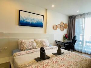 a bedroom with a bed with a desk and a television on the wall at The Astra Bozz Room in Chiang Mai +29 photos