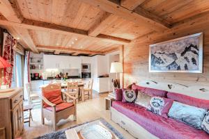 un soggiorno con divano rosso e una cucina di Résidence Hameau De La Blaitiere - 3 Pièces pour 6 Personnes 674 a Chamonix-Mont-Blanc