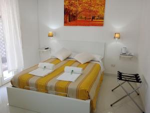 a bedroom with a bed with towels and a chair at Il Focolare in Focene