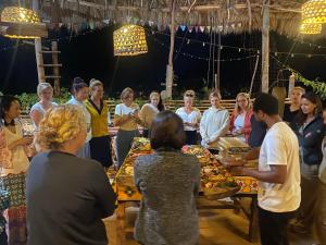 a group of people standing around a table with food at Mount Kilimanjaro 360 view Cottage in Uru