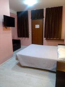 ein Schlafzimmer mit einem Bett, einer Tür und einem TV in der Unterkunft Hotel motel residence Gonzaga in Cantello