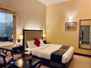 um quarto de hotel com uma cama grande e uma mesa em Status Club Resort em Kanpur