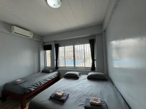 亚兰norndee hostel的带窗户的房间里有两张单人床 更多3张照片