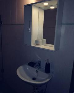 a bathroom with a white sink and a mirror at Orantes Maris Luxury in Katapola