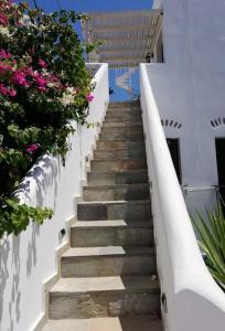 una scala che porta a un edificio fiorito di Orantes Maris Luxury a Katápola