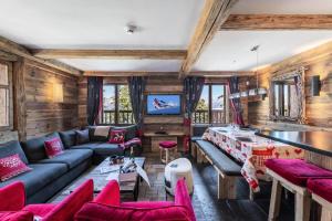 a living room with red furniture and wooden walls at Résidence Ajacour - Chalets pour 8 Personnes 034 in Courchevel