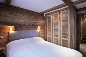 a bedroom with a bed in a wooden wall at Résidence Ajacour - Chalets pour 8 Personnes 034 in Courchevel