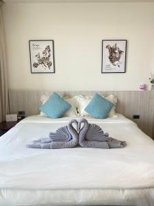 a blanket on top of a white bed at OCEANA HOME Phuket Kamala in Phuket Town