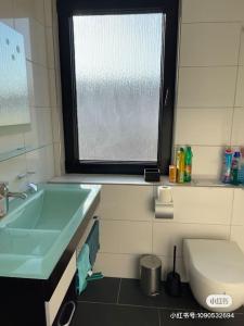 a bathroom with a sink and a toilet and a window at Haus mit 3 Schlafzimmer 3 großen Doppelbetten für bis zu 6 Personen in Garbsen