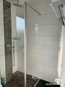een douche met een glazen deur in de badkamer bij Haus mit 3 Schlafzimmer 3 großen Doppelbetten für bis zu 6 Personen in Garbsen