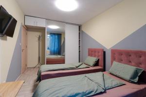 a room with two beds and a television in it at Mirela Guest Apartment in Veliko Tŭrnovo