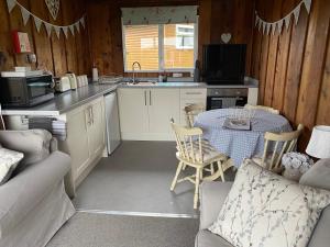 a small kitchen with a table and a couch at Chalet Thirty Two in Seaton