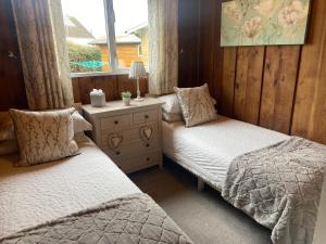 1 Schlafzimmer mit 2 Einzelbetten und einem Fenster in der Unterkunft Chalet Thirty Two in Seaton
