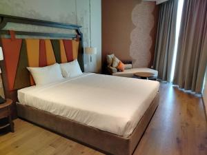 a bedroom with a large white bed and a chair at Apec Mandala Mui Ne Beach Studio in Ấp Thiẹn Ái