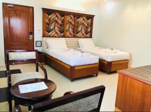 Habitación con 2 camas, mesa y sillas en Naveed Residency en Anantapur