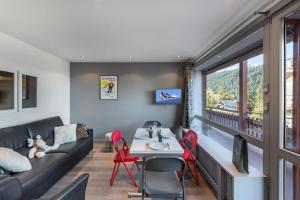 sala de estar con sofá, mesa y sillas en Residence - Studio 514 en Courchevel