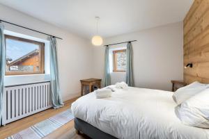 a bedroom with a large white bed and a window at Résidence Blom - Chalets pour 12 Personnes 634 in Saint-Martin-de-Belleville