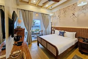 Sea Gadabout - Seaside Stays في بونديتْشيري: غرفه فندقيه بسرير وشرفه