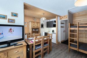 ein Wohnzimmer mit einem TV und einem Esszimmer in der Unterkunft Résidence Roc De Peclet 2 - Studio pour 4 Personnes 414 in Val Thorens