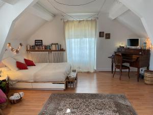 um quarto com uma cama, uma secretária e um piano em Atelier chez Marie em Carnetin
