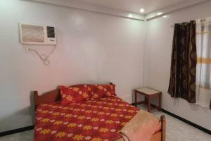 a small bedroom with a bed and a air conditioner at Lemon House in Puerto Galera