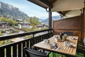 een tafel op een balkon met uitzicht op de bergen bij Résidence Le Coeur Du Mont Blanc - 3 Pièces pour 6 Personnes 164 in Saint-Gervais-les-Bains
