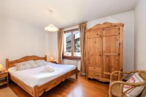 a bedroom with a bed and a wooden cabinet at Résidence Alpes - Pièces 104 in Chamonix