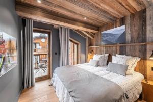 a bedroom with a large bed and a window at Chalet UltreÏa - Pièces 024 in Saint-Martin-de-Belleville