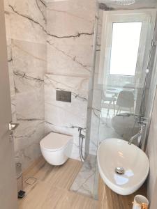 y baño con aseo blanco y lavamanos. en Kasaj Luxury Apartments, en Porto Rafti